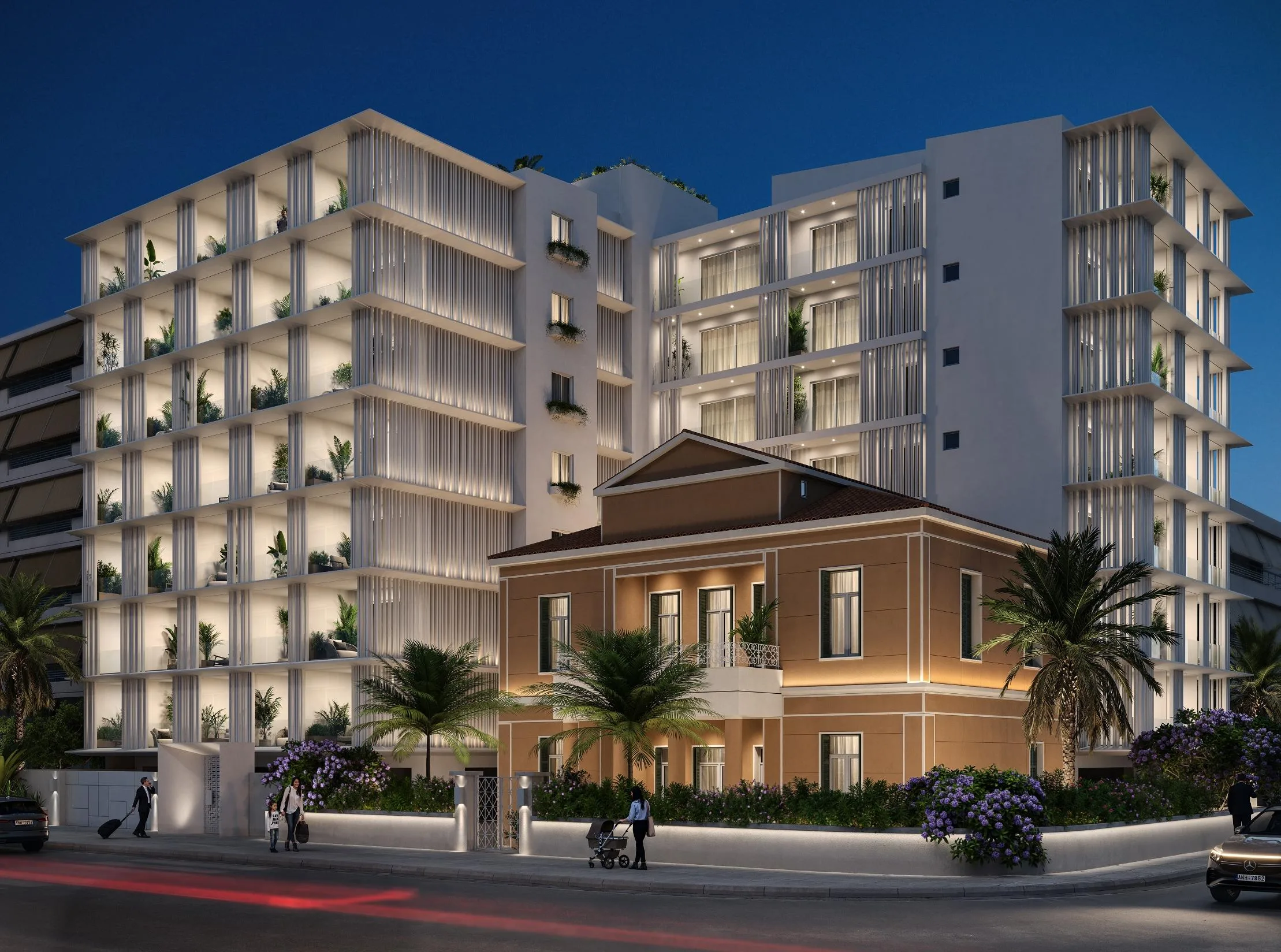 Aenaon Park Residences illuminated at night along the Faliro Bay waterfront