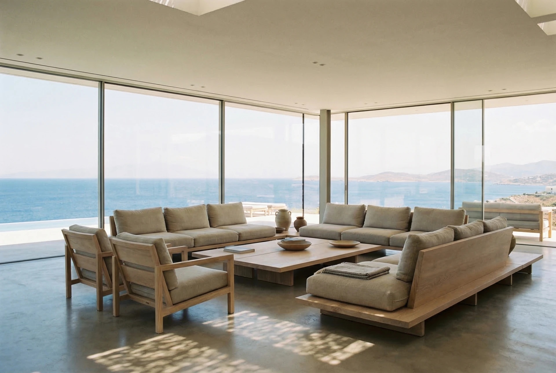 Minimalist living room with floor-to-ceiling glass framing the Aegean