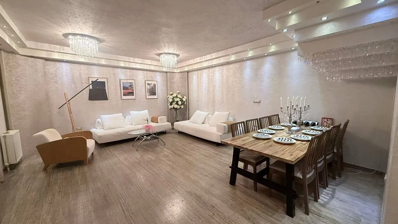 Open living and dining room with dual crystal chandeliers