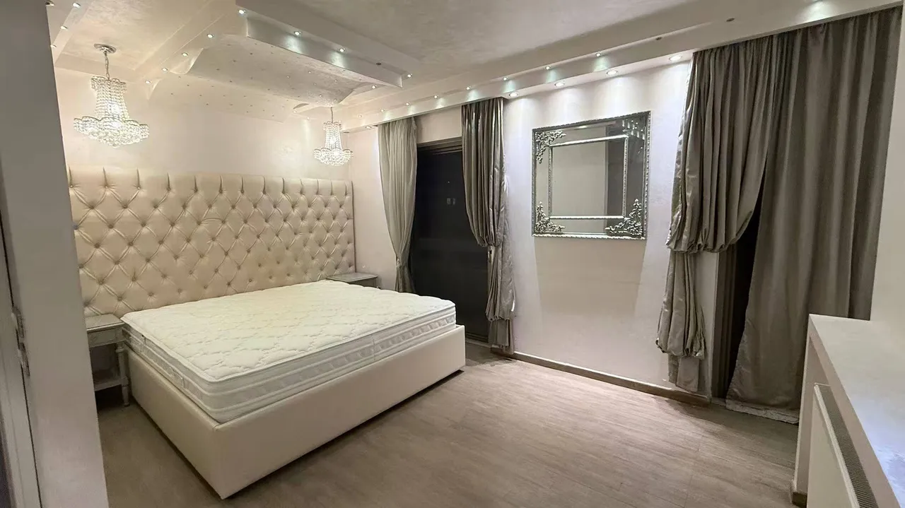 Master bedroom with Capitonné silk headboard